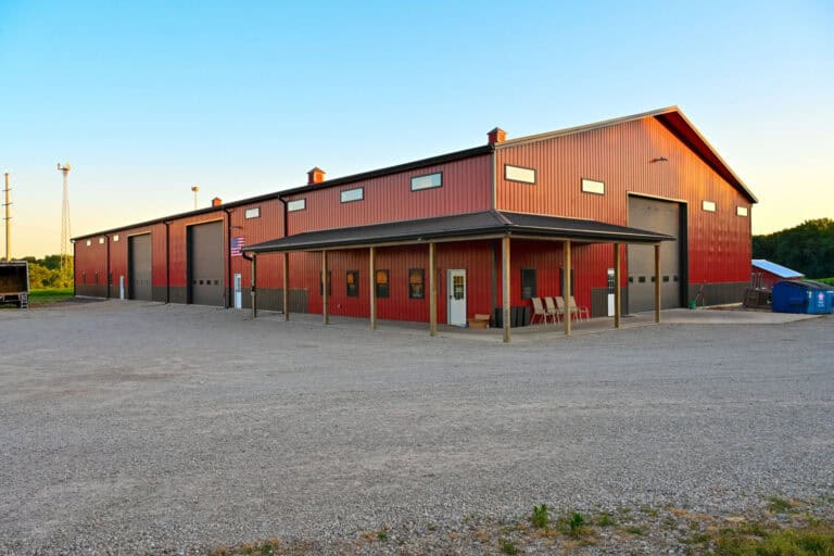 Red post-frame farm shop with oversized garage doors and covered porch in Columbus, Ohio
