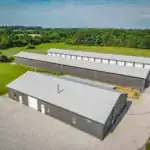 Drone view of Westerville Auto’s industrial-grade facility with multiple garage bays and red roof accents, situated along a major thoroughfare.