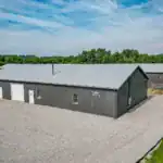 Exterior elevation of Westerville Auto highlighting the custom red steel roof, glass front entry, and tall garage doors built for commercial automotive use.