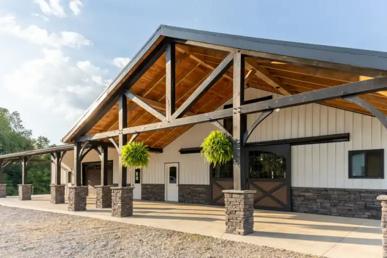 Custom horse barn with heavy timber porch, stone column bases and crossbuck doors in Brinkhaven, Ohio
