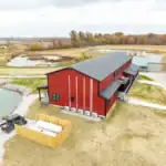 Aerial view of the red two-story Shooting Club lodge overlooking Toussaint River wetlands in Ottawa County, Ohio