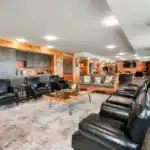 Lounge with leather seating and stone fireplace inside the Shooting Club