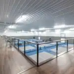 Clear-span interior with multiple pickleball courts at The Backyard